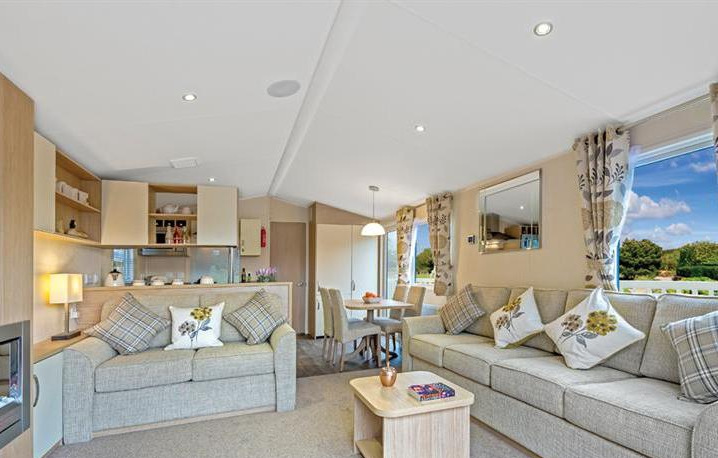 The interior of a holiday lodge for sale in Yorkshire at Brickyard Lakes, decorated in warm yellows and greys with sunflower patterns.