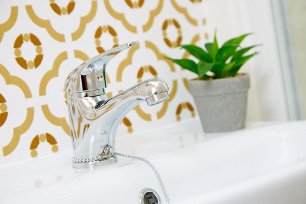 Bathroom tap with a plant in the background in a holiday lodge in North Yorkshire at Brickyard Lakes