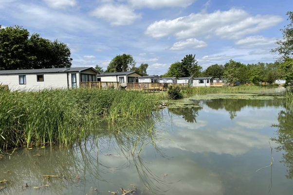 Static caravans on the waterfront at Brickyard Lakes, representing fishing lodge holidays.